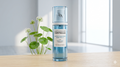TPA Centella Asiatica serum bottle on a wooden surface with a plant in the background